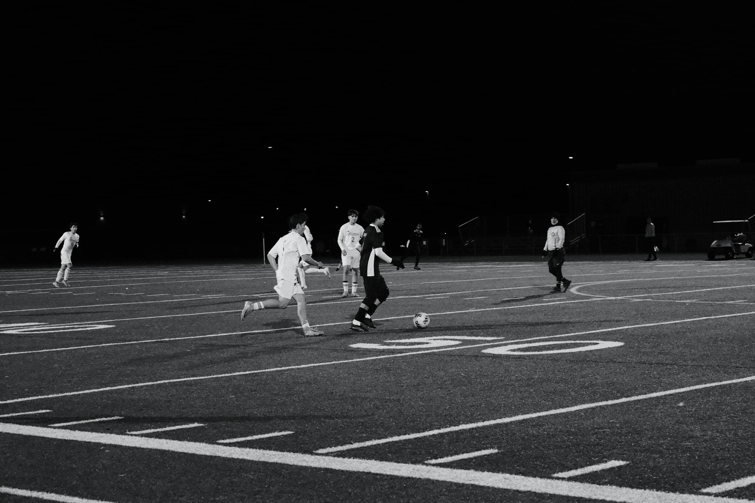 Partido de fútbol nocturno en una cancha de barrio